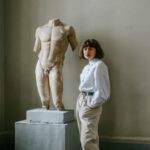 woman standing beside sculpture