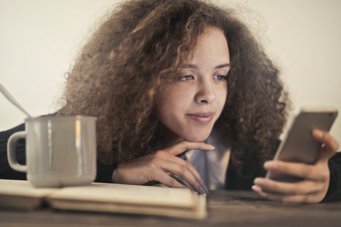 woman in black shirt leaning on brown wooden table